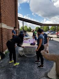 volunteers paint signs at Foster Park school during the 2017 Chicago Cares Serve-a-thon