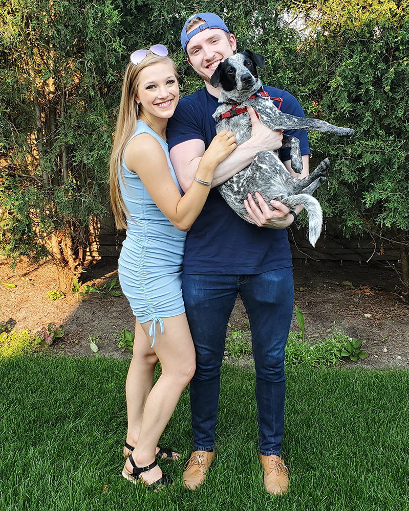 Jessica Hucek, Credico's Senior Onboarding Specialist, smiles next to her boyfriend holding her dog, Oz Paws.