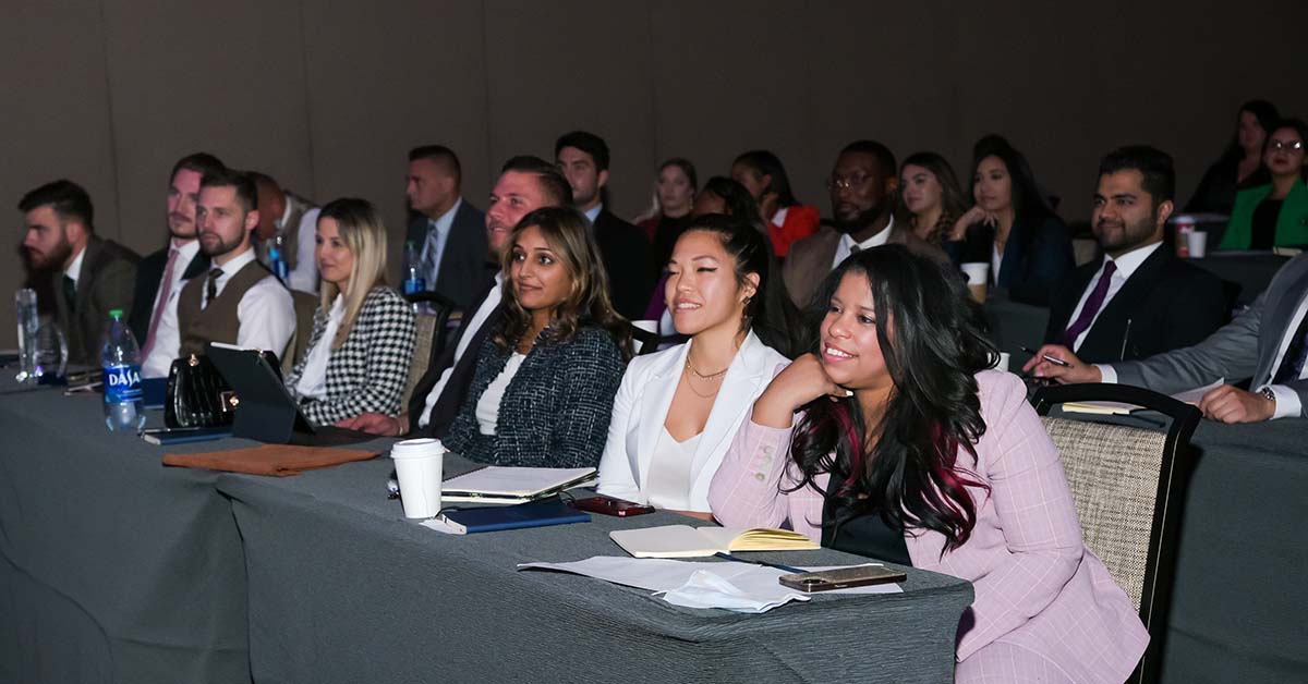 Rows of smiling attendees sit at workshop tables at a 2021 conference in Las Vegas.