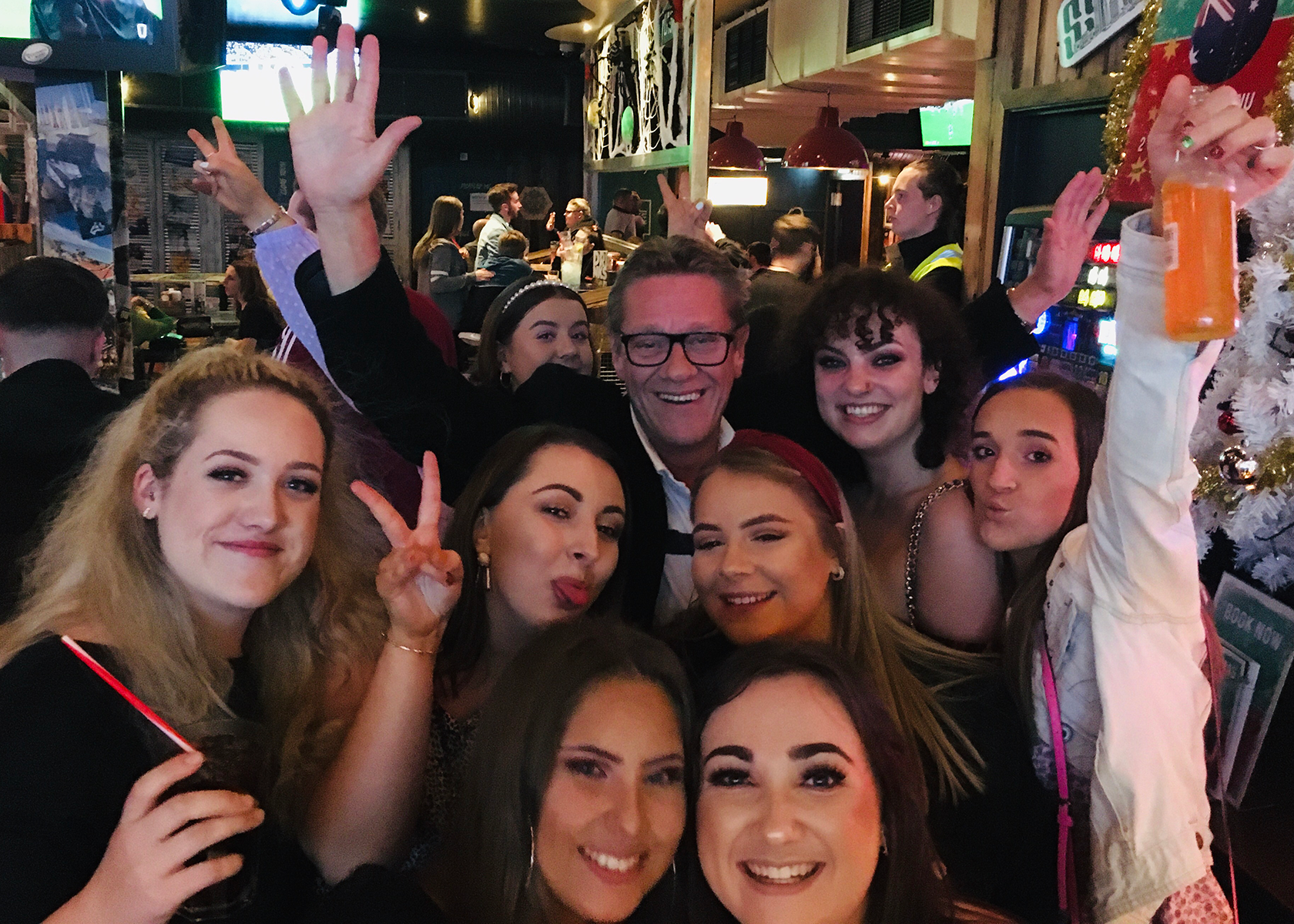 John Dougan waves from the center of a group of celebrating people