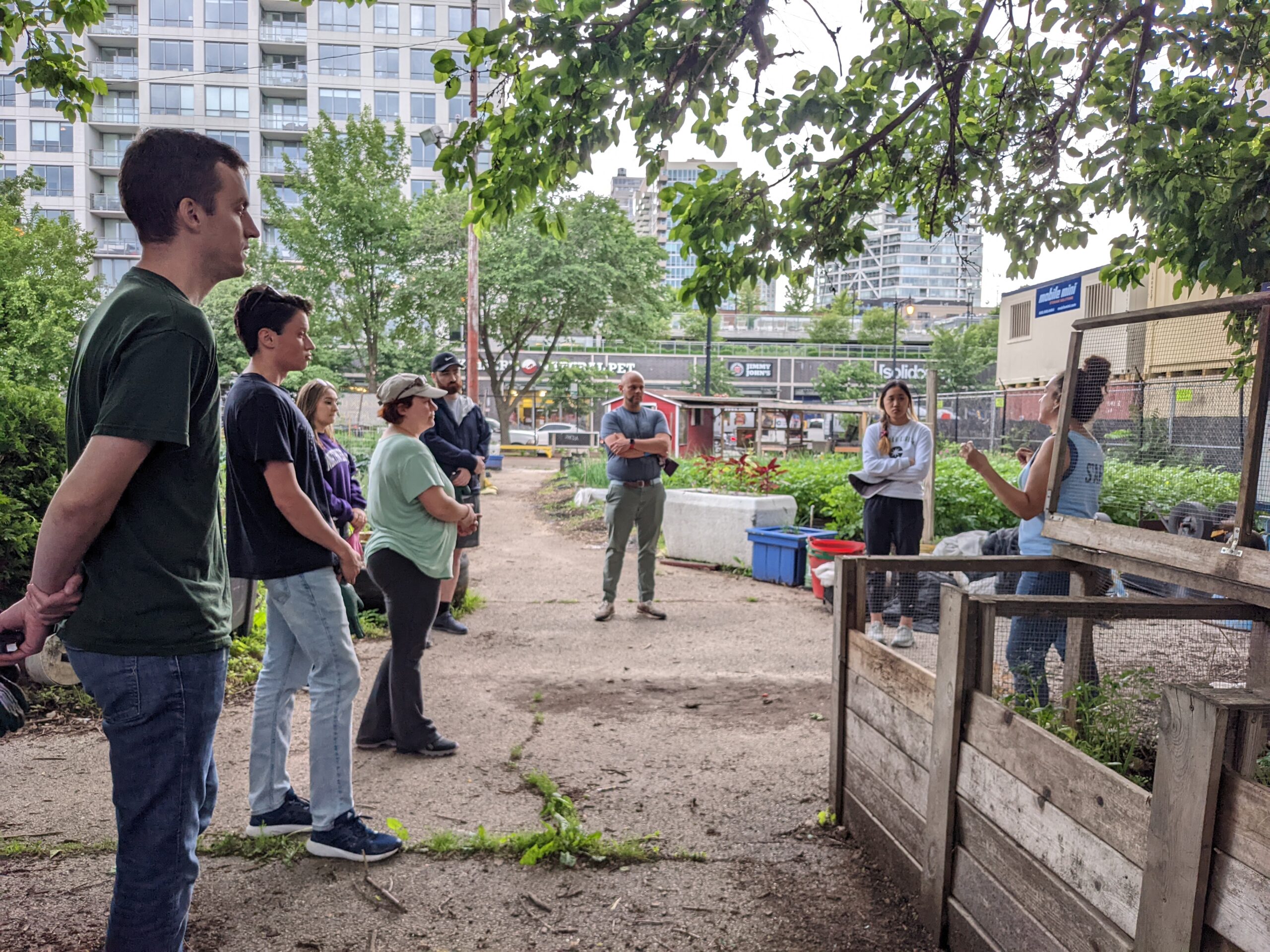 Credico volunteers listen to Urban Farm Associate Director Deja Stout as she outlines the work plan for the day.
