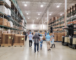 The Credico USA volunteers walk through the warehouse at the Greater Chicago Food Depository.