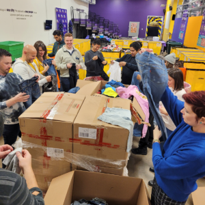 The afternoon group of Credico volunteers sorts through donated clothes at Cradles to Crayons