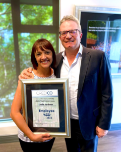 Credico South Africa's Employee of the Year for 2022 Lindie Jordaan stands holding her framed award with Peter van den Berg, CEO of Credico South Africa