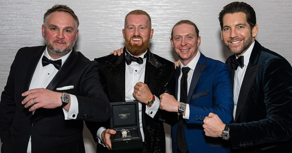 James Sagar, Gavin Walsh, Justin Cobb, and Josh Cote show off their watches in a smiling group photo at the January 2023 North American Awards Gala in Miami, Florida