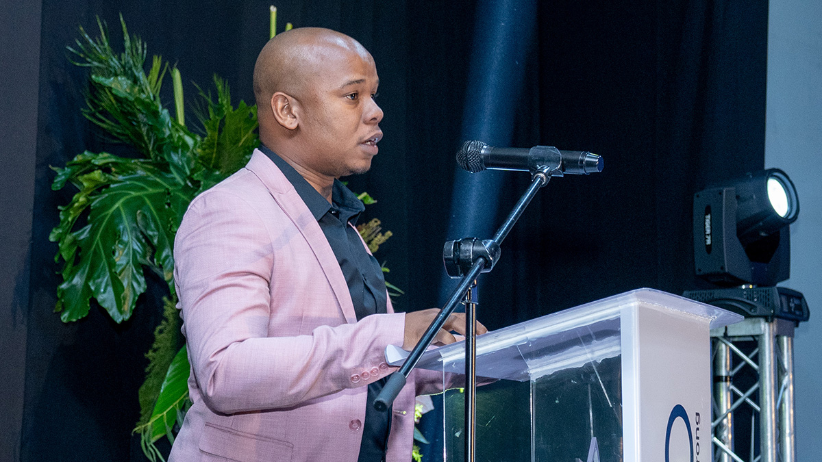 Njabulo Mabaso speaks at a podium on stage at Credico South Africa's 2023 Awards Gala at Sun City Resort