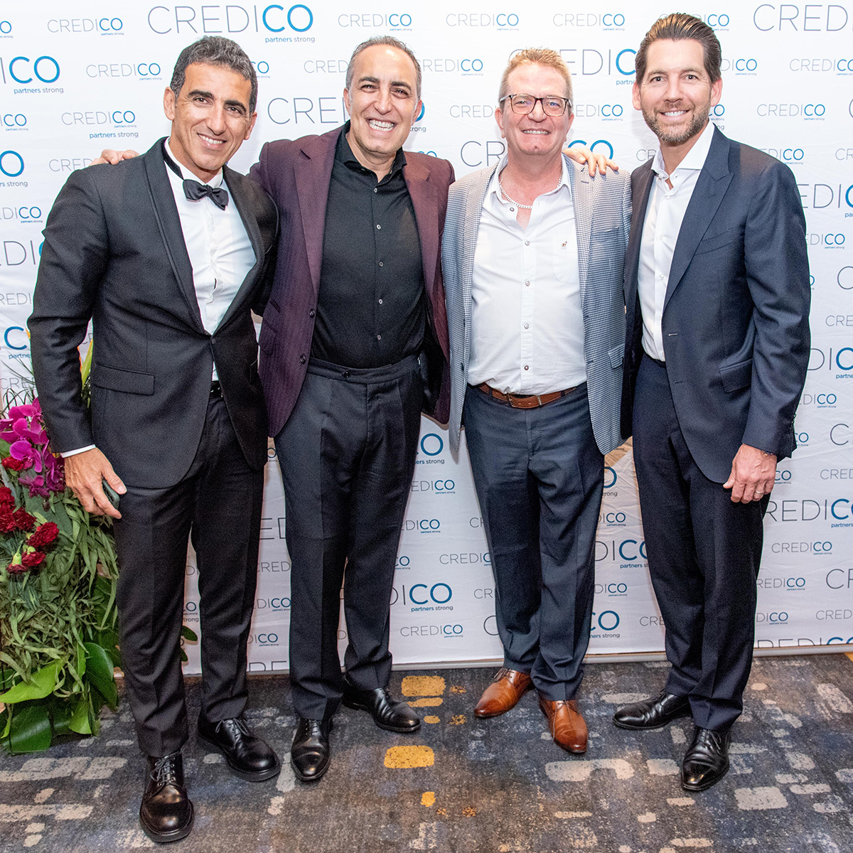 Four leaders, including Antoine Nohra, Peter van den Berg, and Josh Cote, pose for a smiling group photo in front of a Credico-branded backdrop at Credico South Africa's 2023 Awards Gala at Sun City Resort.