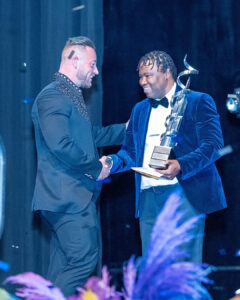 Grant Sherwood hands a trophy to Kevin de Souza on stage at the South Africa Awards Gala in March 2025
