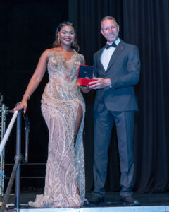 Kagiso Maswanganye poses for a photo with Joseph Spies, holding her new Cartier watch, at the top of the stairs to the stage at the South Africa Awards Gala in March 2025